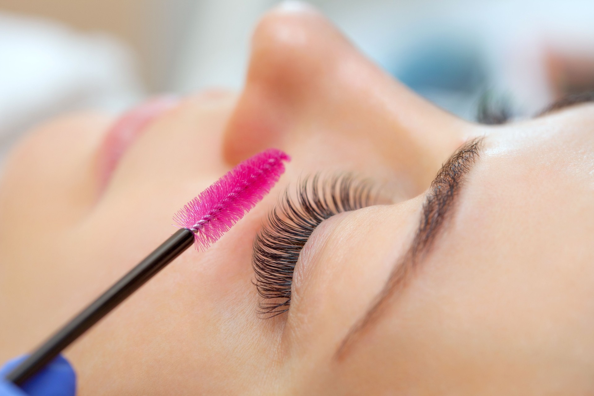 Eyelash extension procedure close up. Beautiful woman with long eyelashes in a beauty salon. Makeup concept